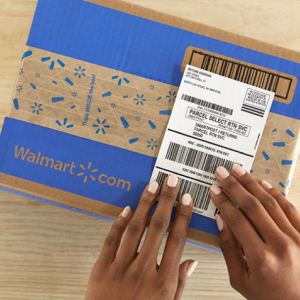 Hands placing shipping label on a Walmart.com branded box